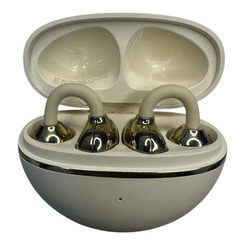 A pair of wireless earbuds in their open charging case, featuring a glossy metallic silver finish with beige silicone ear hooks and a matching beige interior.