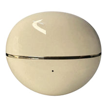 A round, egg-shaped cream-colored cosmetic container with a glossy finish, a horizontal metallic gold band around the middle, and a small black dot near the bottom, shown on a plain white background.