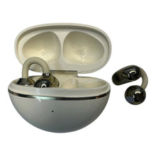 A pair of wireless earbuds with a glossy black finish, shown next to their open charging case which has a cream-colored interior and a silver metallic rim.